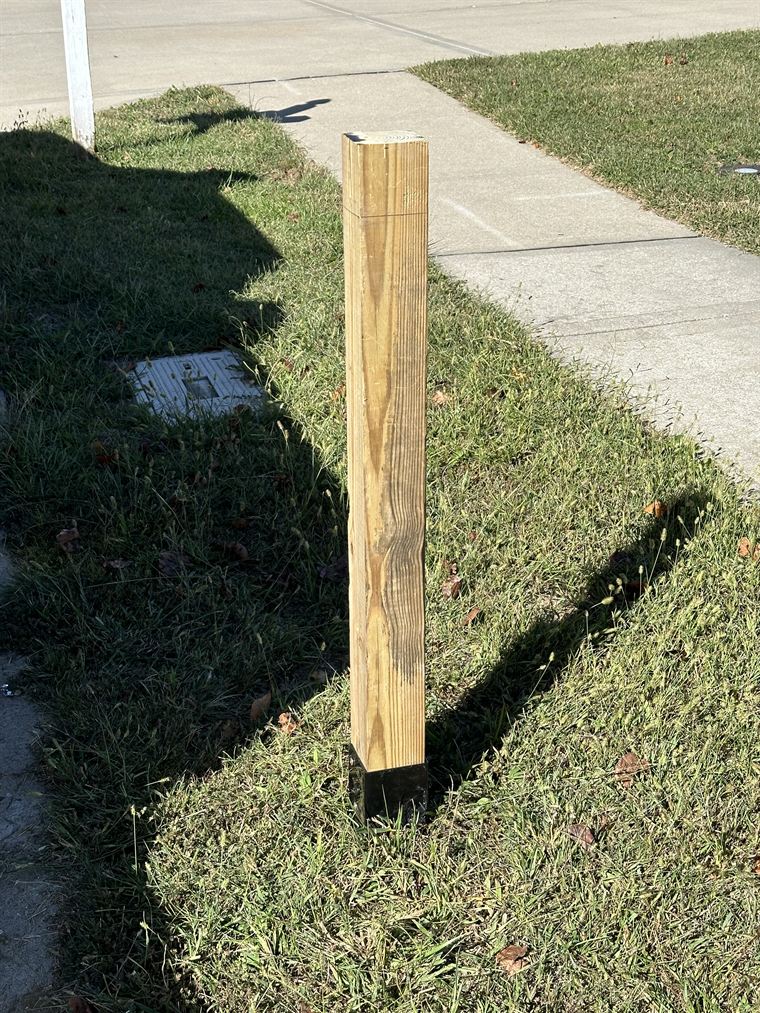 Old weathered wooden mailbox post